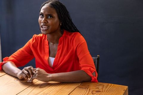 Businesswoman in Red Blouse Reflecting at Modern Office Table