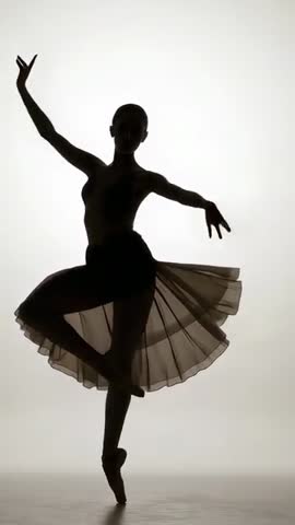 Backlit ballet dancer performing en pointe and turning in tutu | Vertical silhouette video