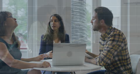 Collaboration in Office with Laptop and Financial Data Visuals