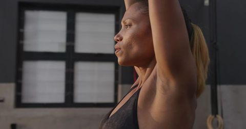 Woman Stretching with Arms Overhead in Modern Fitness Studio