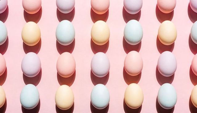 Pastel egg grid on pink background casting long shadows for spring minimal design