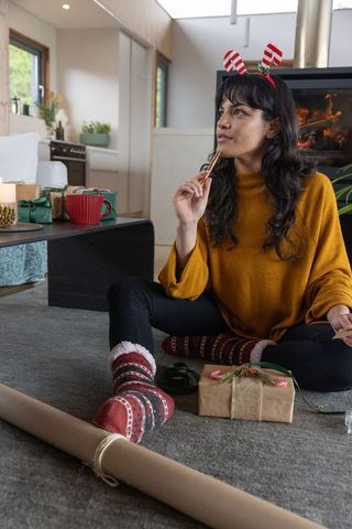 Asian woman ready for holiday gift wrapping festivities with cinnamon stick