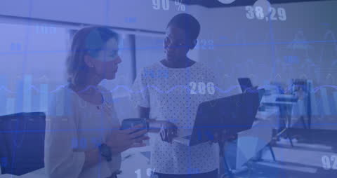 Diverse Businesswomen Analyzing Data on Laptop with Graph Overlays
