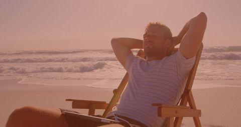Man Relaxing on Beach during Sunset, Enjoying Leisure Time