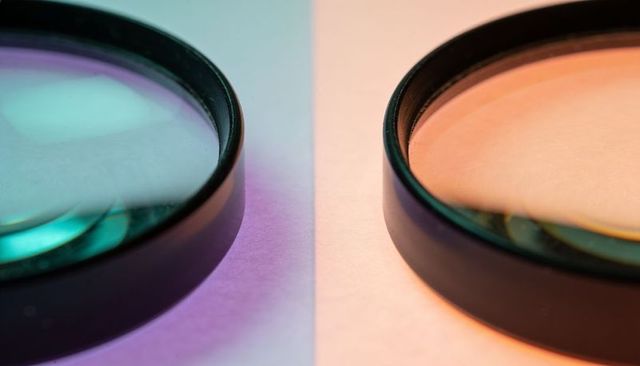 Dual circular lens filters casting teal and peach reflections on split pastel background