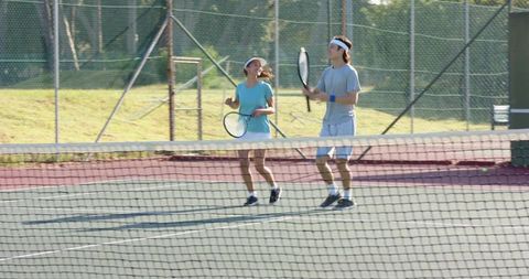 Man and woman playing tennis on outdoor hard court enjoying casual mixed doubles practice