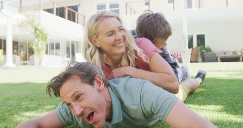 Joyful Family Laughing and Playing on Sunny Lawn