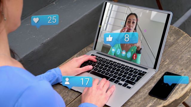 This video captures a woman having an interactive video call on her laptop at a cafe, with social media-like notifications overlaying the screen. It can be used for content related to remote communication, social media engagement, digital interactions, business meetings, and the rise of technology in everyday settings.