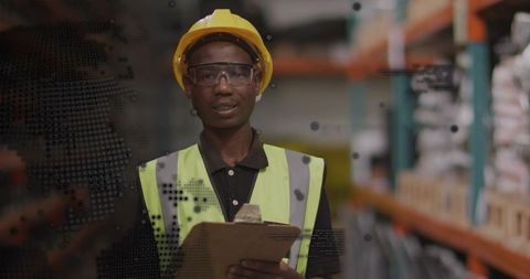 Inspecting Warehouse Inventory While Wearing Hard Hat and Hi-Vis Vest Holding Clipboard