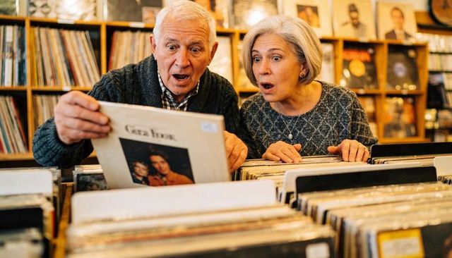 Senior couple discovering vintage vinyl treasures while browsing local record shop