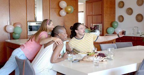 Friends Taking Selfie During Home Dining: Joyful Gathering Moments