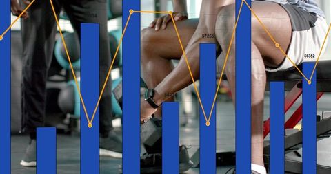 Seated trainee reaching down grabbing hex dumbbell while coach spotting, fitness forecast