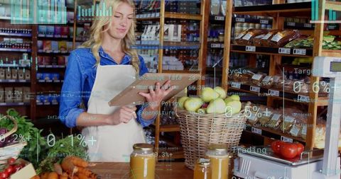 Grocer using tablet for digital inventory in rustic market with fresh produce and jars