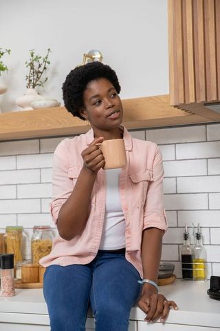 Relaxed Woman Enjoying Coffee on Kitchen Counter