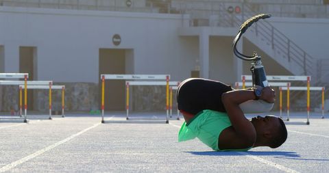 Determined athlete with prosthetic leg preparing for track event