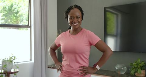 African american woman standing at home smiling with hands on hips wearing smartwatch