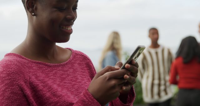 Woman Texting on Smartphone at Outdoor Social Gathering - Download Free Stock Images Pikwizard.com