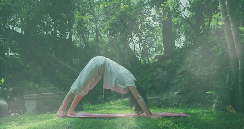Woman Practicing Yoga Outdoors in Lush Garden Setting