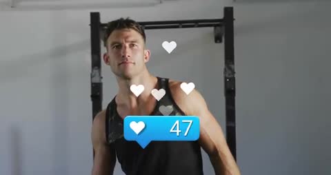 Fit athlete turning to camera while gaining social media likes during gym workout with heart overlay