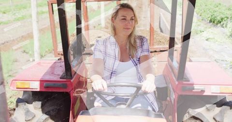 Woman driving tractor on farm under clear sky