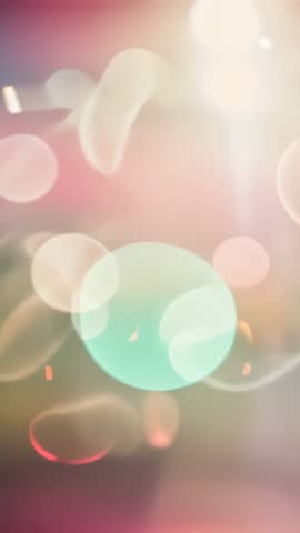 Vertical abstract bokeh animation with drifting pastel orbs, teal glow and rising light beam