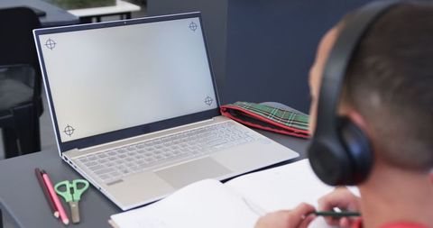Young Adult Focusing on Laptop with Blank Screen for Copy Space