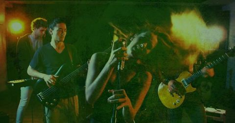 High-energy band performing lead singer leaning into vintage mic yellow guitar