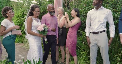 Bride and Groom Holding Hands During Joyful Outdoor Wedding