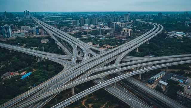 Aerial perspective of multilayer highway interchange weaving through urban skyline and greenery