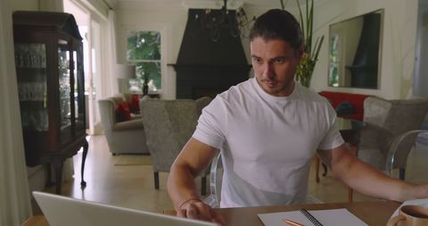 Young Man Organizing Wedding on His Laptop from Home Office