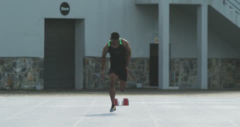 Athlete Starting Sprint on Track at Stadium