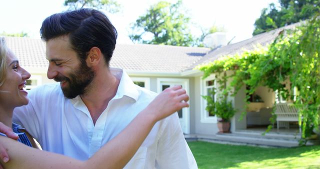 Cute couple smiling and holding each other in front of a house on a sunny day  - Download Free Stock Photos Pikwizard.com