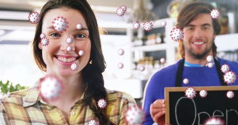 Smiling Retail Worker Amidst Viral Particles and Open Sign