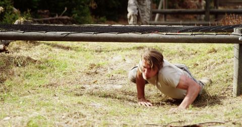 Determined Military Personnel Crawling Through Obstacle Course Challenge - Download Free Stock Images Pikwizard.com