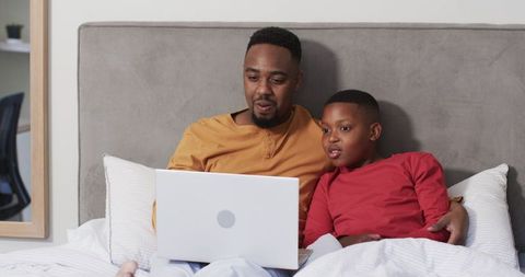 Father and Son Bonding Online on Bed, Relaxed Modern Bedroom Setup