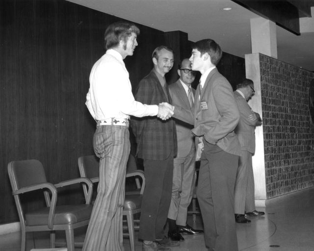 High school student greets astronauts during a tour of Marshall Space Flight Center after winning a nationwide scientific competition. The contest involved proposing experiments for the upcoming Skylab mission. This image can be used for articles on educational programs, NASA history, student contests, science education, and space exploration.