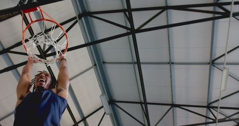 Energetic Basketball Player Dunking at Indoor Court