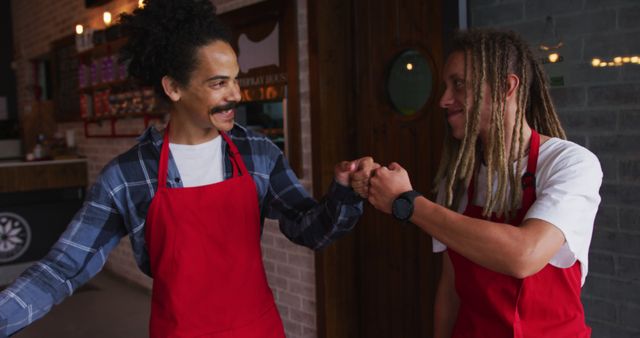 Café Staff Fist Bumping and Smiling in Red Aprons - Download Free Stock Images Pikwizard.com