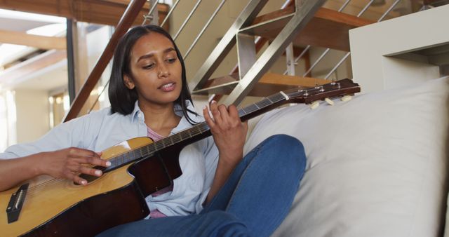 Young Woman Relaxing at Home Playing Guitar - Download Free Stock Images Pikwizard.com