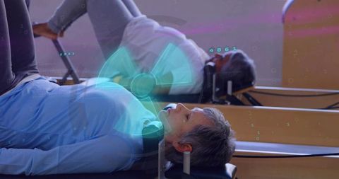 Senior woman performing reformer Pilates in group class improving balance and mobility