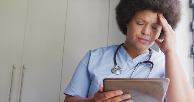 Image of tired plus size african american female doctor using tablet - Download Free Stock Photos Pikwizard.com