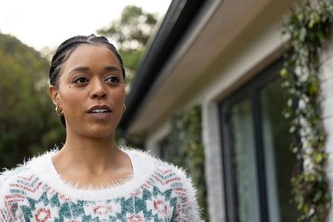 African american woman speaking outdoors in cozy fluffy sweater and gold hoop earrings