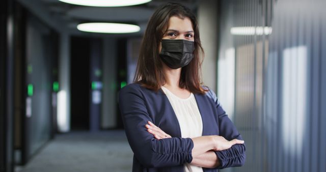 Portrait of caucasian businesswoman with brown hair wearing face mask in modern office. business and business people in office during covid 19 pandemic concept.