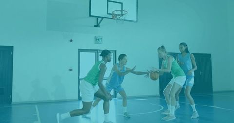 Female Basketball Players Competing for Ball Under Hoop in Indoor Court Practice Drill
