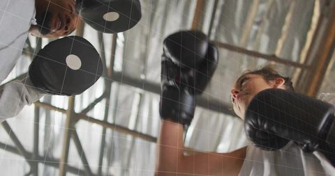 Female Boxer Training with Coach in Industrial Gym Setting