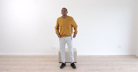 Confident young man standing in minimalist interior