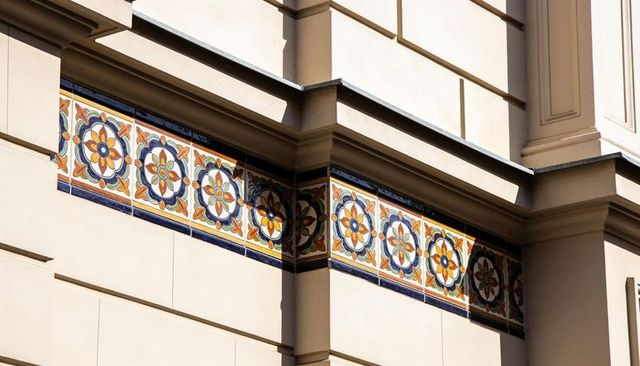 Ornate ceramic tile frieze decorating historic building facade