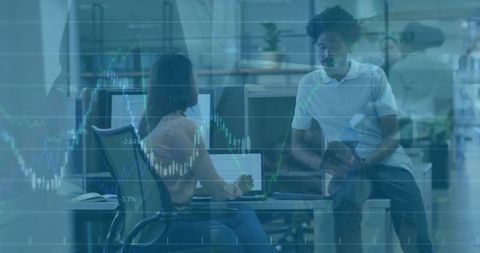 Colleagues Engaged in Data Analysis with Financial Chart Overlay