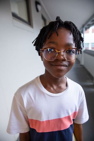 Boy with Glasses in Urban Setting Smiling Outdoors