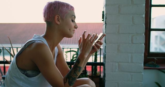 Young Woman with Pink Hair Texting on Smartphone on Balcony - Download Free Stock Images Pikwizard.com